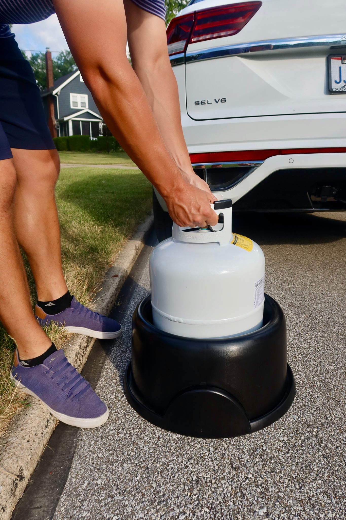 Agriculture propane tank sitting on a farm field with a bright blue sky and white clouds in the background.